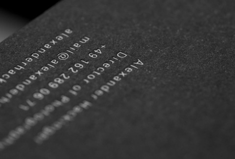 Die Adresse ist mit weißer Heißfolienprägung auf der Rückseite der schwarzen Visitenkarte zu sehen.